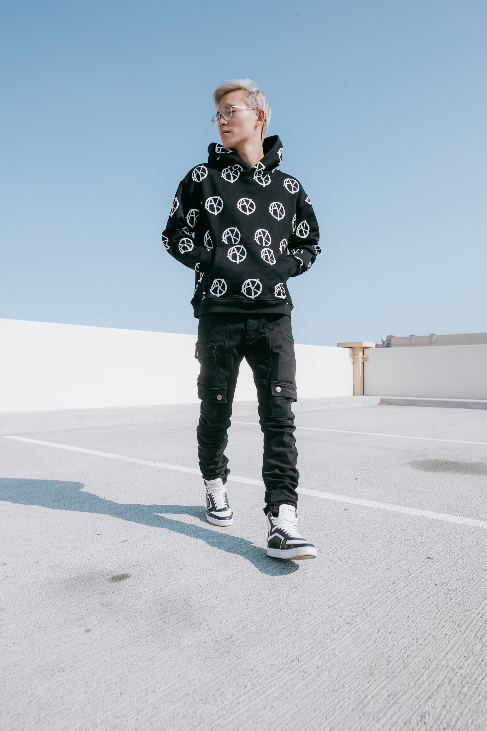 A man wearing logo black hoodie, black cargo stacked pants, and Celine Z Trainers outfit ideas