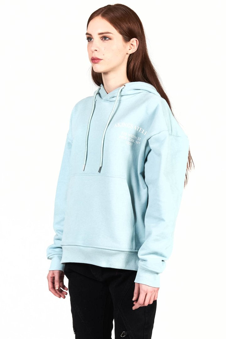 a female model wearing a size medium of atelier hoodie in sky blue