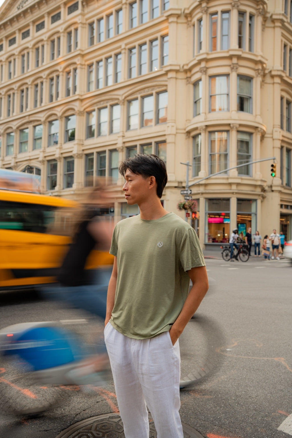 Model standing on a city street with blurred background in color green