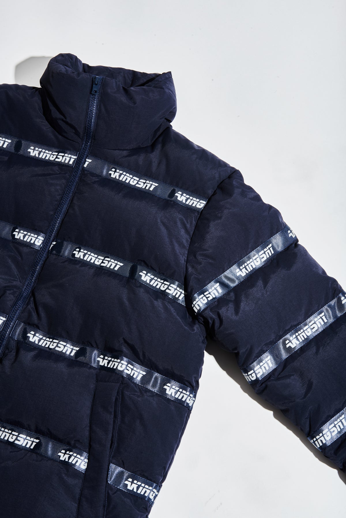 Detail of quilting and logo patch on navy puffer
