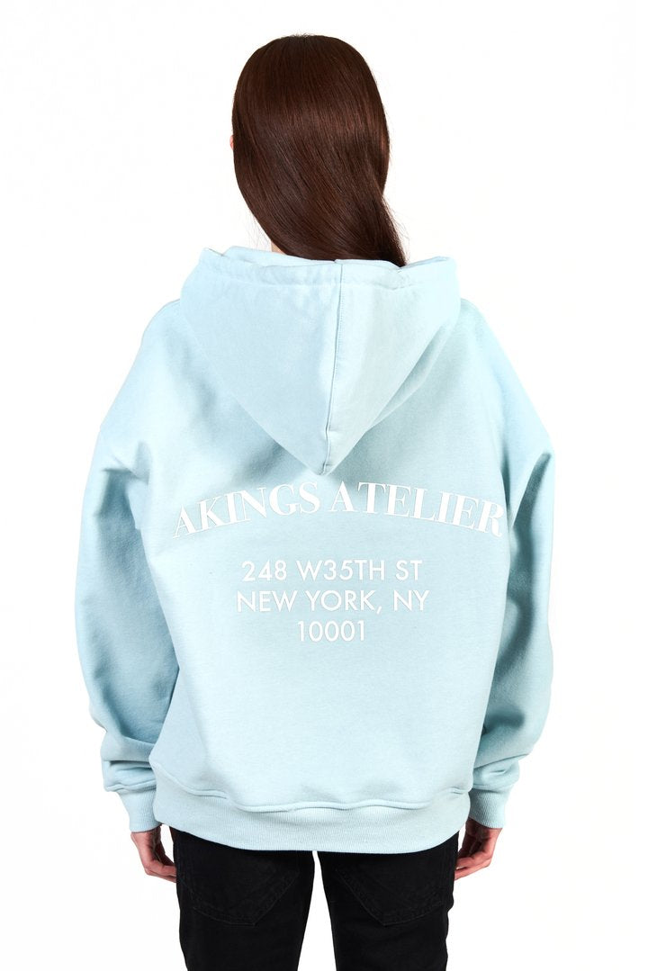 back view of atelier hoodie showing the screen print in white and hoodie off